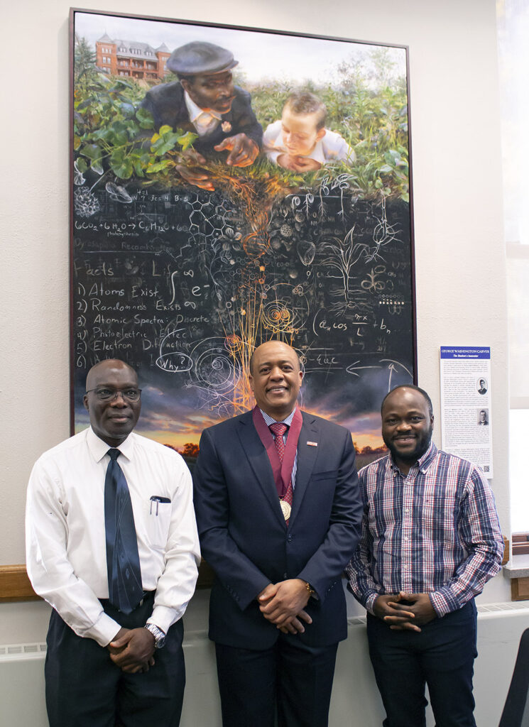 From left, David Kwaw-Mensah, Walter Suza and Boris Alladassi in front of a painting featuring Carver. 